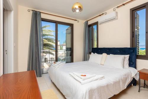 ein Schlafzimmer mit einem Bett und einem Tisch und Fenstern in der Unterkunft Villa Iliana in Polis Chrysochous