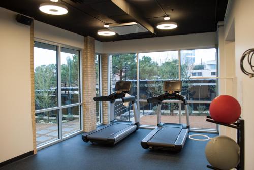 a gym with two elliptical machines and a large window at Lorenzo Hotel Dallas, Tapestry Collection by Hilton in Dallas