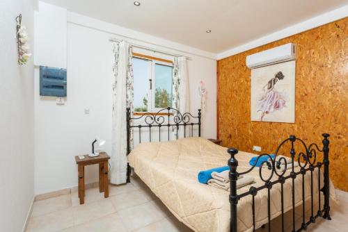a bedroom with a black bed and a window at Villa Paradiso Sunset in Pomos