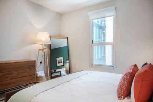 ein Schlafzimmer mit einem großen weißen Bett und einem Fenster in der Unterkunft SoMa 1BR w Gym Roofdeck BBQs nr Tech HQs SFO-97 in San Francisco