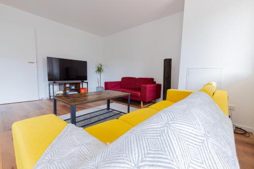 sala de estar con sofá amarillo y mesa en FLAIR: Ruheoase vor der Stadt en Mannheim