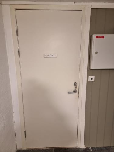a large white door with a sign on it at Near Bergen City, Apartment 7 min from the airport, free parking in Bergen