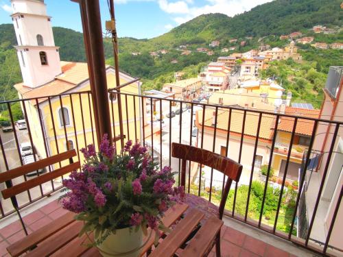 a balcony with a table with purple flowers on it at Nennella Cilento House in Cuccaro Vetere