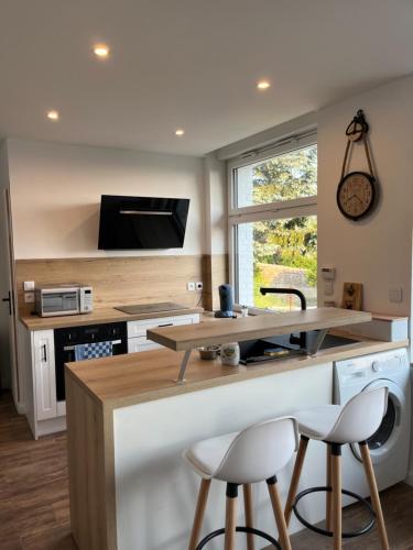 - une cuisine avec un comptoir et deux tabourets dans l'établissement Le petit paradis, à Cassel