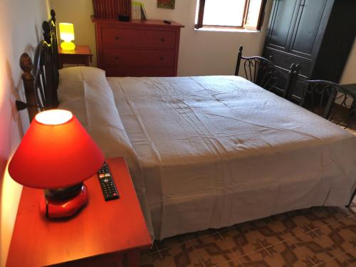 a bedroom with a bed with a red lamp on a table at Nennella Cilento House in Cuccaro Vetere