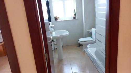 a bathroom with a sink and a toilet and a window at Beiramar in Muxia