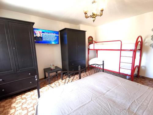 a bedroom with two bunk beds and a tv at Nennella Cilento House in Cuccaro Vetere