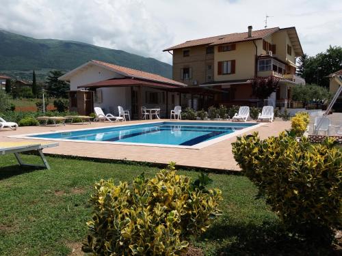 a swimming pool in front of a house at Bed & Breakfast Ciancaleoni in Rivotorto