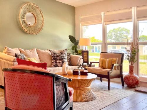 a living room with a couch and a tv at Hummingbird Hideaway, Tropical 3-Bed Guest House in South Tampa in Tampa
