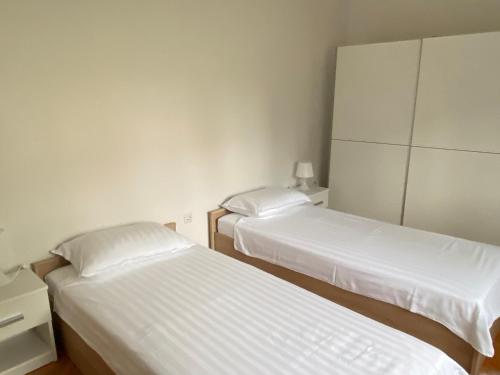 two beds in a small room with white sheets at Apartment Vodnjan in Vodnjan