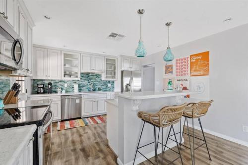 a kitchen with white cabinets and two bar stools at Southwestern Style Home Near Old Town Scottsdale in Scottsdale