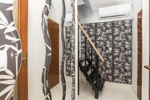 a staircase with a black and white patterned wall at Apartments Paris in Umag