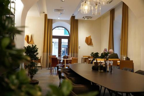 une salle à manger avec des tables et des chaises ainsi qu'une fenêtre dans l'établissement Hotel Platani, à Trebinje