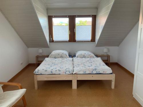 Dormitorio pequeño con cama en el ático en Ferienwohnung-Loesch en Neuenburg am Rhein