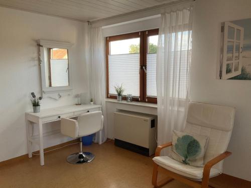ein Wohnzimmer mit einem Schreibtisch und einem Stuhl in der Unterkunft Ferienwohnung Lösch in Neuenburg am Rhein