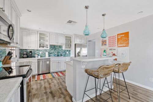 a kitchen with white cabinets and bar stools at Southwestern Style Home Near Old Town Scottsdale in Scottsdale