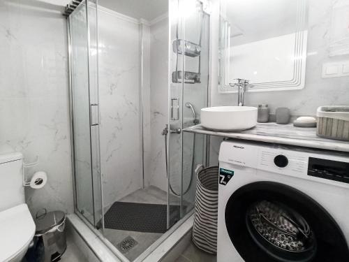 a bathroom with a shower and a washing machine at Kremou Studio in Athens