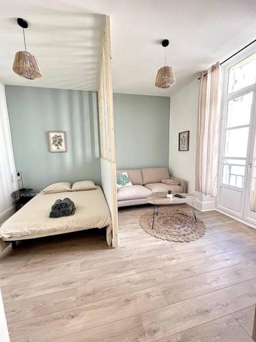 une chambre avec un lit, un canapé et une table dans l'établissement L'Aventurine - Romans, à Romans-sur-Isère