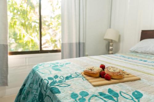 dos pasteles en una tabla de cortar en una cama en Summer Specials! 800 M to Samara Beach! Outdoor Workspace en Sámara