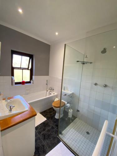 une salle de bains avec douche, toilettes et lavabo dans l'établissement @Leisure Guest Suite, à Stellenbosch