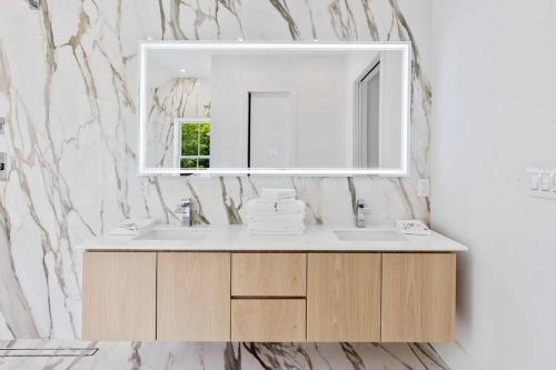 een badkamer met een wastafel en een spiegel bij Charming 7-Bedroom Southampton Compound in Southampton