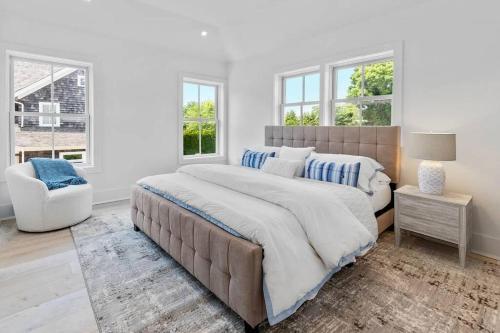 um quarto branco com uma cama grande e uma cadeira em Charming 7-Bedroom Southampton Compound em Southampton