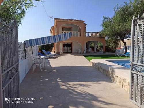 een huis met een zwembad en een hek bij Villa Chalet Riomar Playa Oliva in Oliva