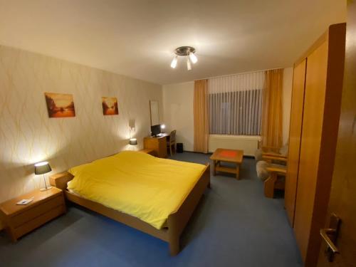 een slaapkamer met een geel bed in een kamer bij Hotel Altitude in Burg-Reuland