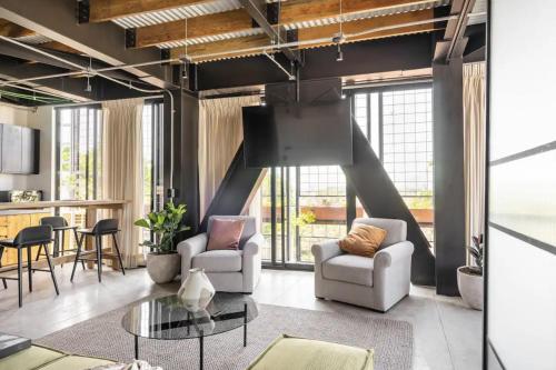a living room with two chairs and a table at Argentina by Pardela - LOFT nuevo Colonia Americana in Guadalajara
