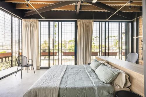a bedroom with a large bed and large windows at Argentina by Pardela - LOFT nuevo Colonia Americana in Guadalajara