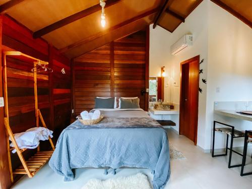 a bedroom with a bed with a wooden wall at Sítio Balango: Seu refúgio em Domingos Martins. Chalés para casais e casa para grupo de pessoas in Domingos Martins