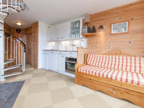 une cuisine avec des armoires blanches et un canapé dans une pièce dans l'établissement Charmant duplex pour 6 personnes avec cheminée et balcon exposé sud à Avoriaz - FR-1-314-199, à Morzine