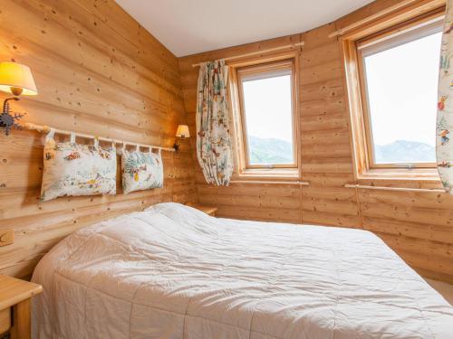 - une chambre avec des murs en bois et un lit avec des fenêtres dans l'établissement Charmant duplex pour 6 personnes avec cheminée et balcon exposé sud à Avoriaz - FR-1-314-199, à Morzine
