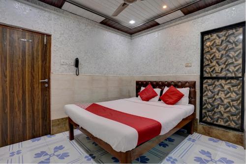 a bedroom with a bed with red pillows at OYO Flagship Hotel Sapna Residency in Mumbai