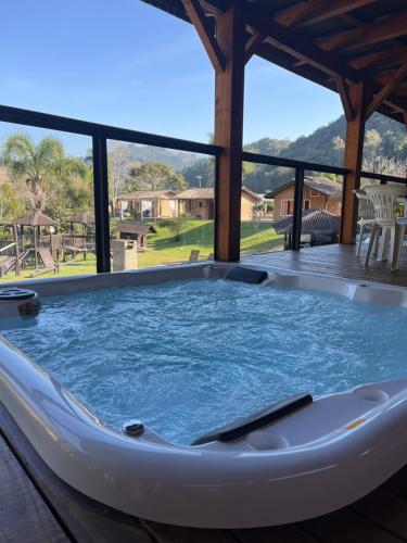 a jacuzzi tub on the deck of a house at Pousada das Hortênsias in São Bonifácio