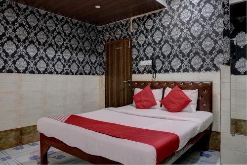een slaapkamer met een groot bed met rode kussens bij OYO Flagship Hotel Sapna Residency in Mumbai