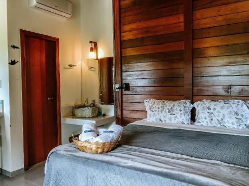a bedroom with a bed with a basket on it at Sítio Balango: Seu refúgio em Domingos Martins. Chalés para casais e casa para grupo de pessoas in Domingos Martins