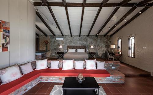 a living room with a red couch and a bed at Secret Harbour Boutique Hotel and Marina in Lance aux Épines