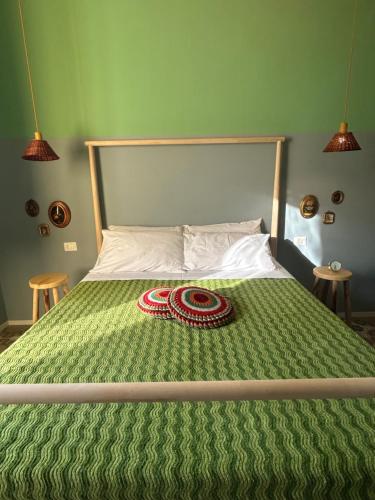 a bed with a green comforter with a red coil on it at Don Ciccio Capashome in Ceglie Messapica