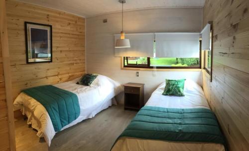 a bedroom with two beds and a window at Santa Dominga in Licán Ray