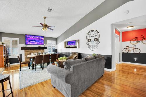 a living room with a couch and a dining room at Sports Themed--Automated King Bed--Family Friendly--5 miles to Strip in Henderson
