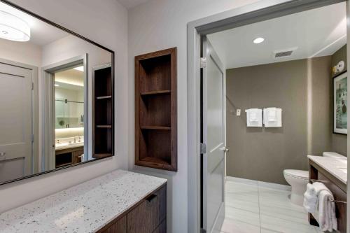 a bathroom with a mirror and a sink and a toilet at Residence Inn by Marriott Atlanta Covington in Covington