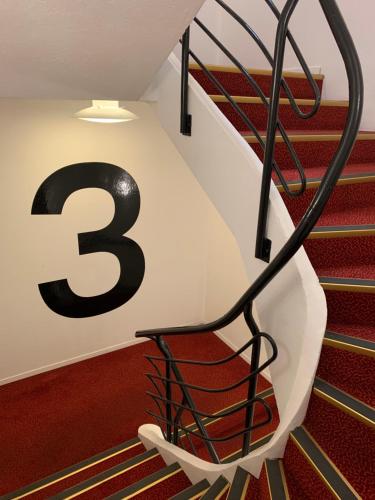 a spiral staircase with the number three on the wall at Bodø Hotel in Bodø