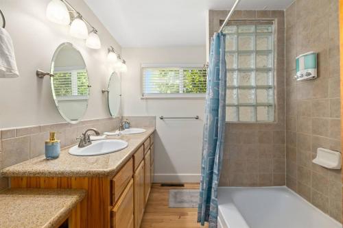 uma casa de banho com 2 lavatórios, uma banheira e um chuveiro em 1950s Charmer em Boise
