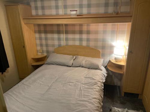 a bed in a small room with two nightstands and a bed with at Chestnut grove, Thorpe park in Humberston