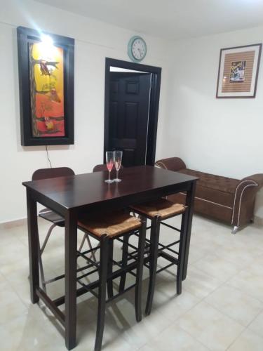 a dining room table and chairs with wine glasses on it at Departamentos velasco in Tijuana