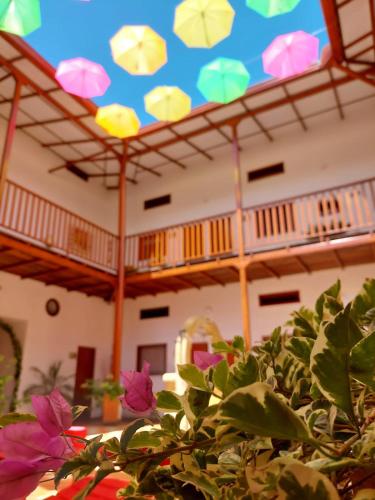 a room with a table with flowers and a ceiling with umbrellas at HOTEL BOUTIQUE SIMACOTA in Simacota