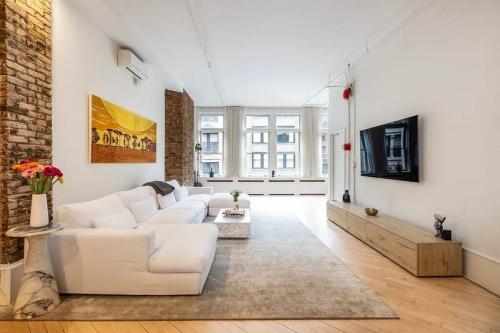 a living room with white furniture and a brick wall at Luxurious 2 Bedroom Loft Entire Apartment in New York