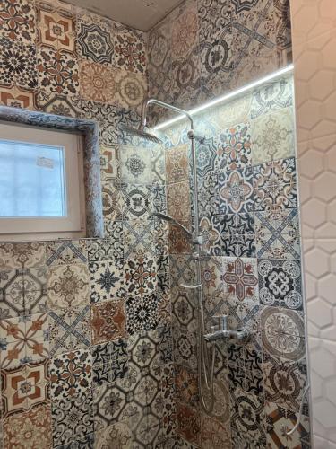 a bathroom with a shower with tiles on the wall at Davud Apartments in Sarajevo
