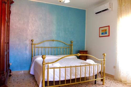 1 dormitorio con 1 cama con pared azul en Le Terrazze sulle Eolie, en Caronia Marina